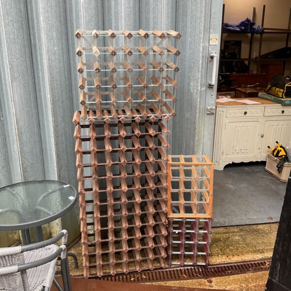 Lot of four wood and metal wine racks stacked together outdoors