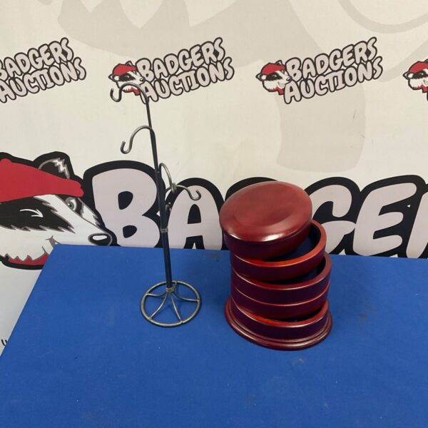 Red wooden jewellery box stacked in tiers beside a wire necklace hanger