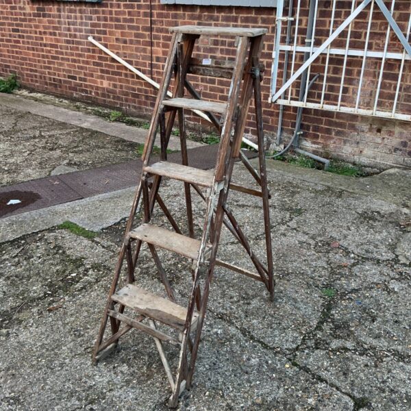 Weathered wooden step ladder with flat top platform and stepped treads