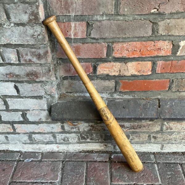 Wooden Wilson baseball bat with natural timber finish and stamped barrel mark
