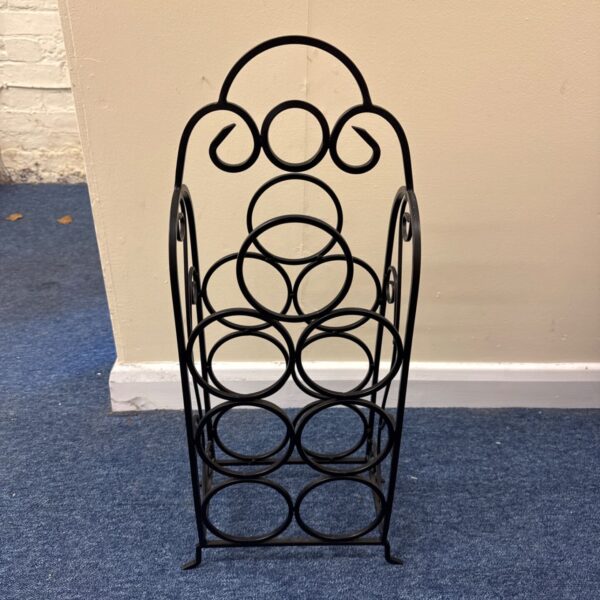 Black wrought iron seven bottle wine rack with scrolled arched top