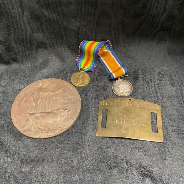 WW1 Death Penny, Victory Medal, British War Medal and Shropshire Light Infantry tag on dark cloth