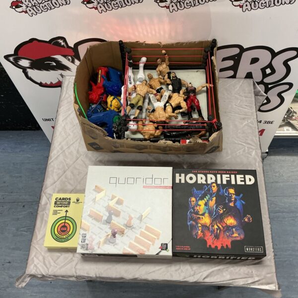 WWE wrestling ring with figures beside board games and toy blasters in a lot