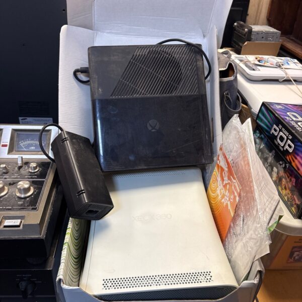 White Xbox 360 console boxed with Xbox One and power supply.