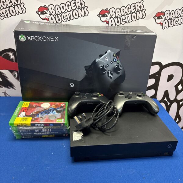 Xbox One X console boxed with games and controllers.
