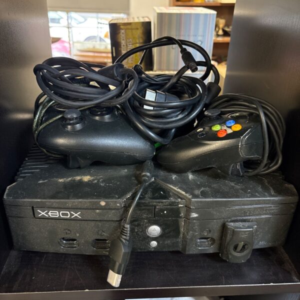 Black original Xbox console with two controllers and tangled cables