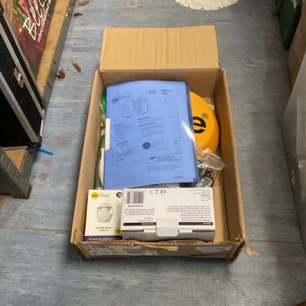 Box of Yale alarm system kits and dummy cameras for home security.
