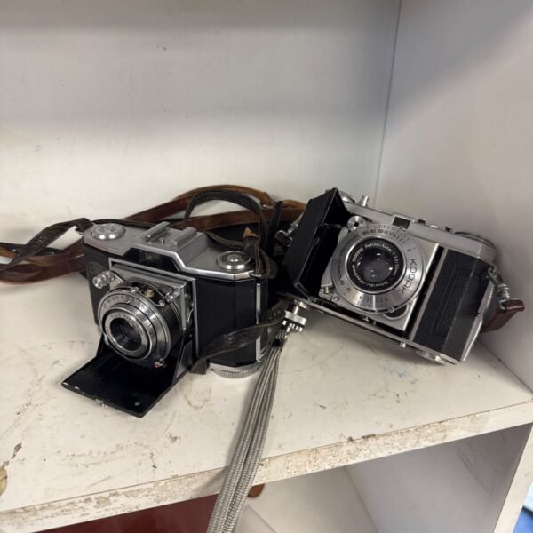 Vintage Zeiss Ikon Contina and Kodak Retina cameras on display.